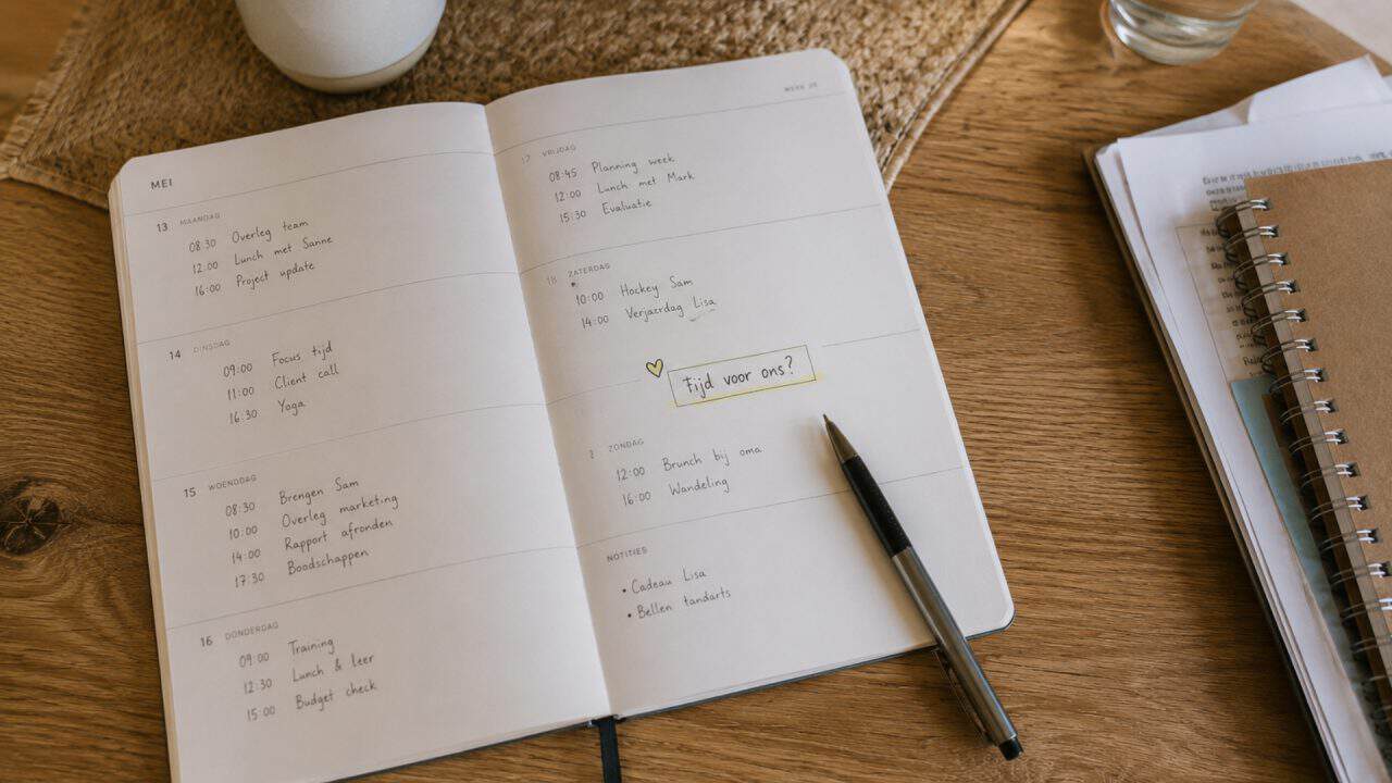 Weekplanner vol afspraken met handgeschreven notitie “tijd voor ons?”